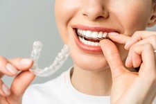 una-giovane-donna-esegue-una-procedura-di-sbiancamento-dei-denti-a-casa-vassoio-sbiancante-con-gel2.jpg